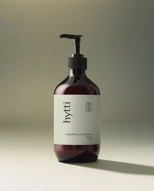 Amber pump bottle of Grapefruit & Arctic Berry hand wash with the Hytti label, casting a long shadow