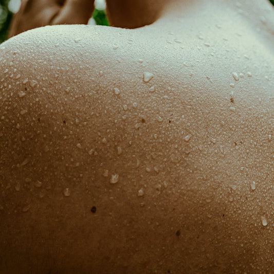 Close view of a bare shoulder and upper back beaded with sweat after a sauna